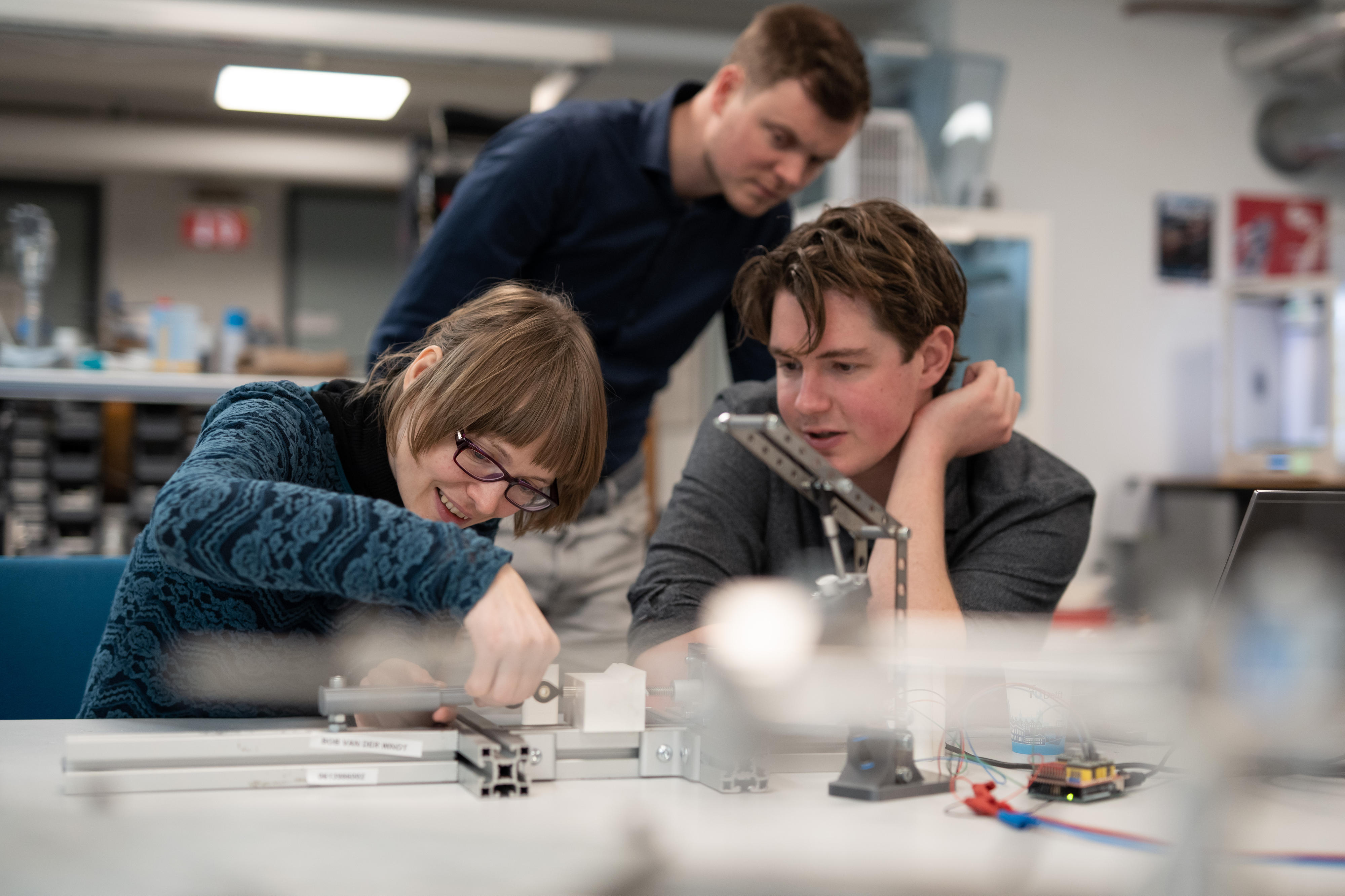 Three people sitting in the lab talking