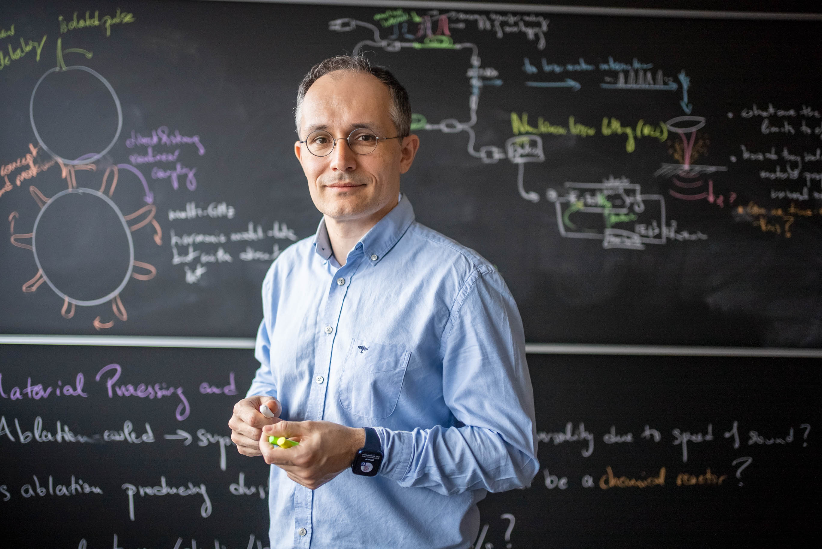 A person standing in front of a black-board